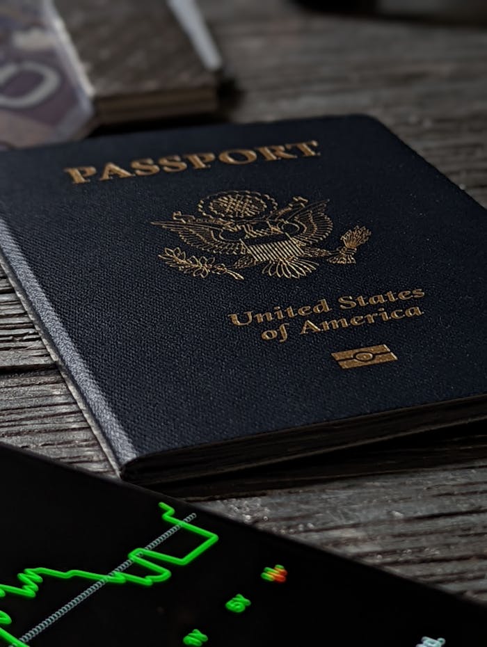 hero-img-02 Close-up of a United States passport on a rustic wooden table with a smartphone nearby.